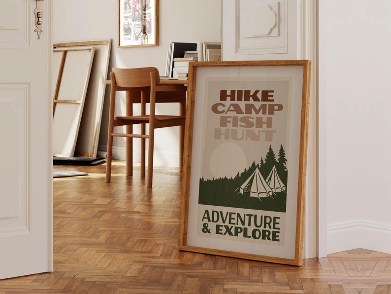May include: A framed poster with a vintage design featuring a forest scene with two tents and the text "HIKE CAMP FISH HUNT ADVENTURE & EXPLORE".