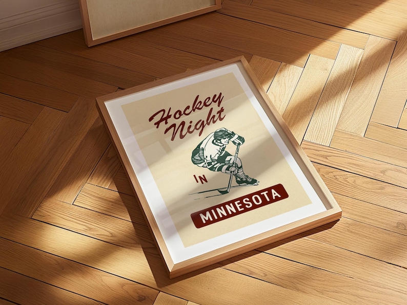 Puede incluir: P&oacute;ster enmarcado de estilo vintage con el texto "Hockey Night in Minnesota". La obra de arte presenta a un jugador de hockey en acci&oacute;n, en verde, blanco y negro. El p&oacute;ster est&aacute; sobre un fondo crema.