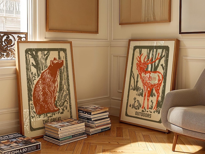 Op de afbeelding: Twee ingelijste prints met een natuurthema. De print aan de linkerkant toont een bruine beer in een bossetting met de tekst "The Great". De print aan de rechterkant toont een edelhert in een bossetting met de tekst "Outdoors".