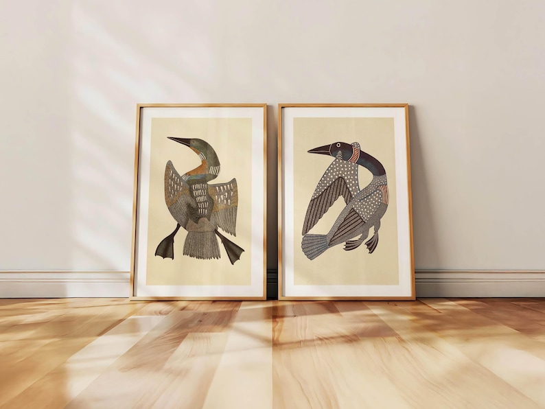 May include: Two framed art prints featuring stylized illustrations of birds. The birds have detailed feather patterns in shades of brown, gray, and black, set against a cream-colored background. The frames are a natural wood color, adding a warm touch to the artwork.