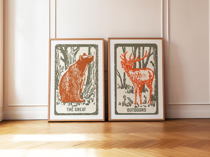 Op de afbeelding: Twee ingelijste prints met een bosachtergrond. De print aan de linkerkant toont een bruine beer die in het bos zit. De print aan de rechterkant toont een rood hert dat in het bos staat. De print aan de linkerkant heeft de tekst "The Great" en de print aan de rechterkant heeft de tekst "Outdoors".