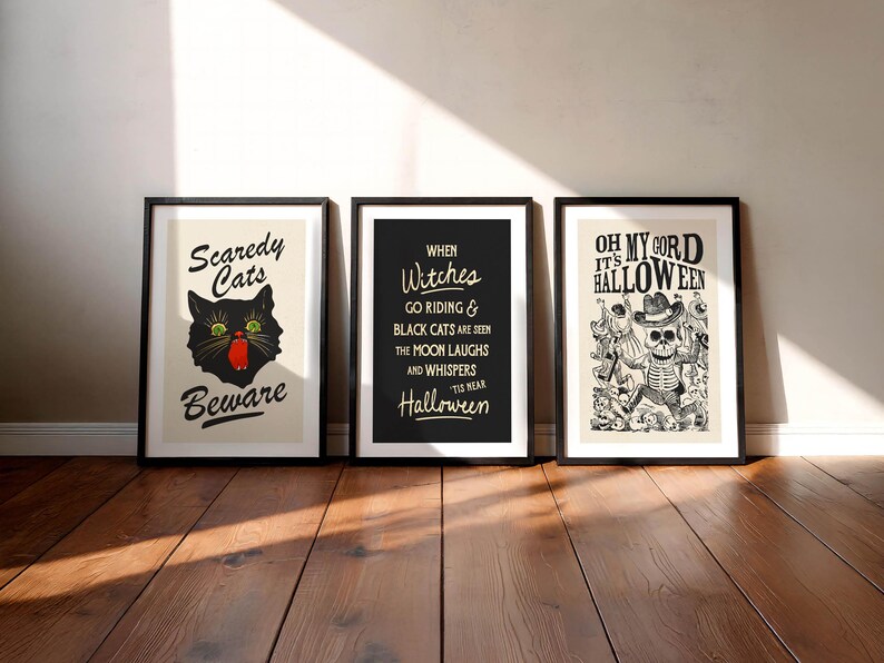 May include: Three framed Halloween-themed art prints. The first features a black cat with green eyes and the text "Scaredy Cats Beware." The second has the text "When Witches Go Riding." The third says "Oh My Cord It's Halloween."