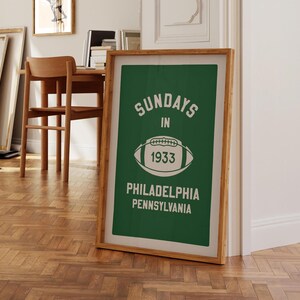K&ouml;nnte beinhalten: Ein gerahmter gr&uuml;n-wei&szlig;er Druck mit dem Text "Sundays in 1933 Philadelphia Pennsylvania" und einer wei&szlig;en Fu&szlig;ballgrafik.