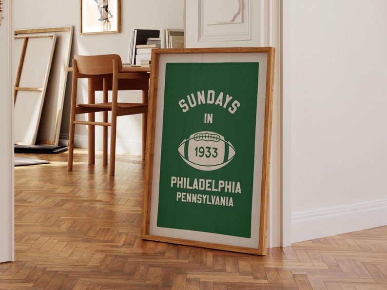 K&ouml;nnte beinhalten: Ein gerahmter gr&uuml;n-wei&szlig;er Druck mit dem Text "Sundays in 1933 Philadelphia Pennsylvania" und einer wei&szlig;en Fu&szlig;ballgrafik.