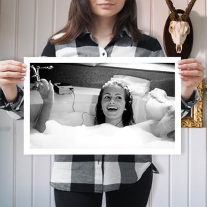 Peut inclure: Photographie en noir et blanc d'une personne dans un bain rempli de bulles, &eacute;coutant de la musique avec des &eacute;couteurs.