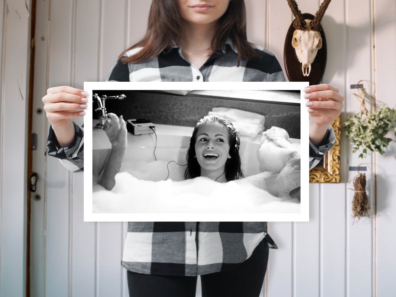 Peut inclure: Photographie en noir et blanc d'une personne dans un bain rempli de bulles, &eacute;coutant de la musique avec des &eacute;couteurs.