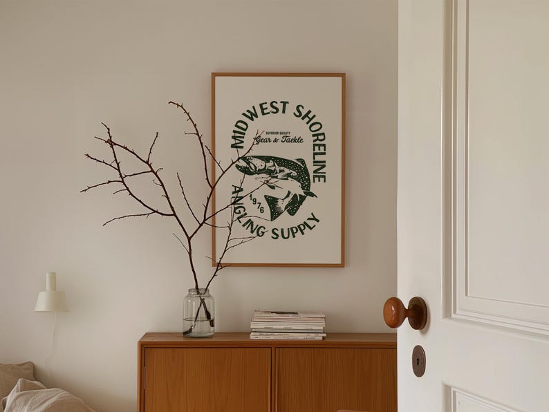 May include: A framed print with a white background and a green circle logo that says "Midwest Shoreline Angling Supply 1976 Gear & Tackle". The logo features a stylized image of a fish.