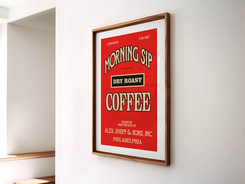 May include: A framed vintage coffee advertisement with a red background. The text reads "MORNING SIP DRY ROAST COFFEE" in a decorative font. The frame is a warm brown colour. The text includes "ALEX. SHEPP & SONS, INC. PHILADELPHIA".