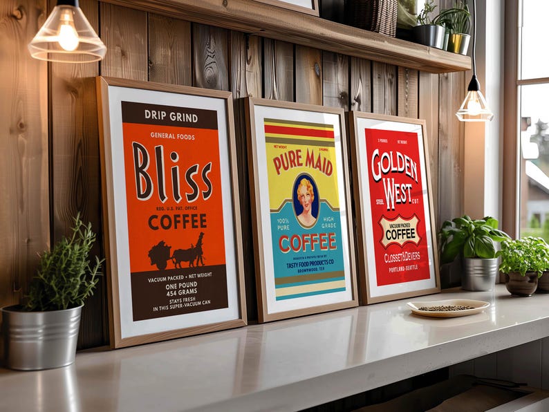 May include: Three framed vintage coffee advertisements. The Bliss Coffee poster is orange with black text and illustrations. The Pure Maid Coffee poster is yellow and blue with a woman's portrait. The Golden West Coffee poster is red with white text.