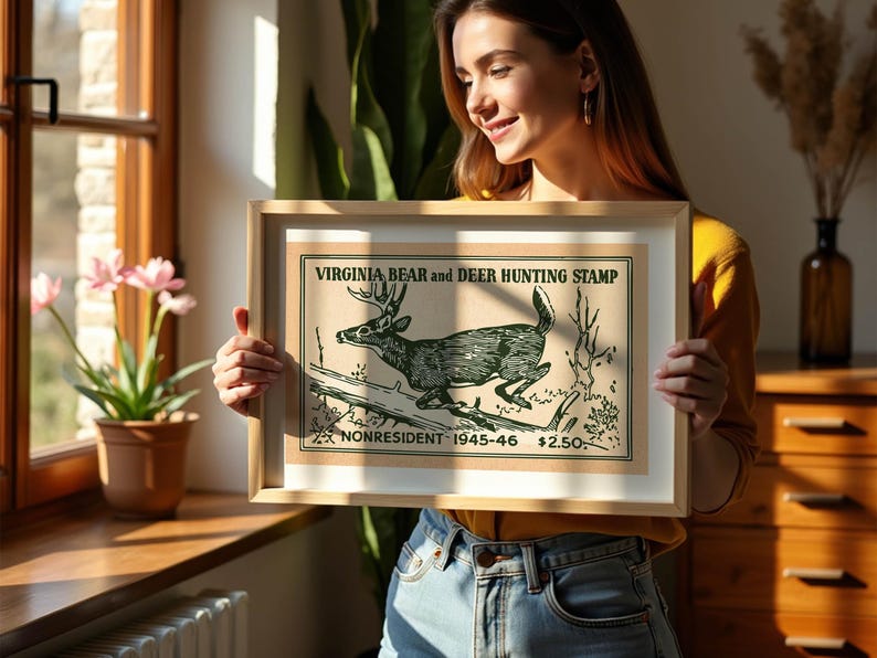 May include: Framed vintage Virginia Bear and Deer Hunting Stamp print. The artwork features a detailed illustration of a deer leaping over a log. The text reads "Virginia Bear and Deer Hunting Stamp" and "Nonresident 1945-46".