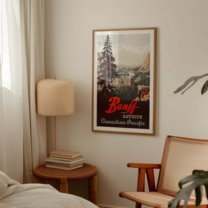 May include: A vintage travel poster with a brown wooden frame. The poster features a scenic view of Banff National Park in the Canadian Rockies. The text on the poster reads "Banff in the Canadian Rockies Canadian Pacific".