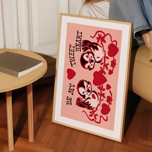 May include: A pink framed print with a red and white illustration of two birds with the text "Be My Tweet Heart" on a pink background.