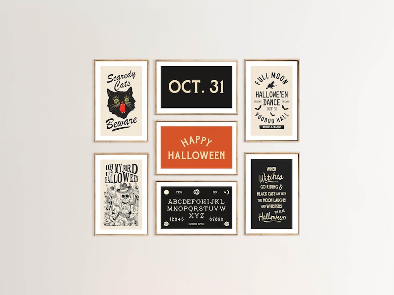 May include: A collection of framed Halloween-themed art prints. The prints feature spooky text and graphics, including a black cat, a Ouija board, and the phrases "Happy Halloween" and "Oct. 31". The color palette includes black, orange, and cream.