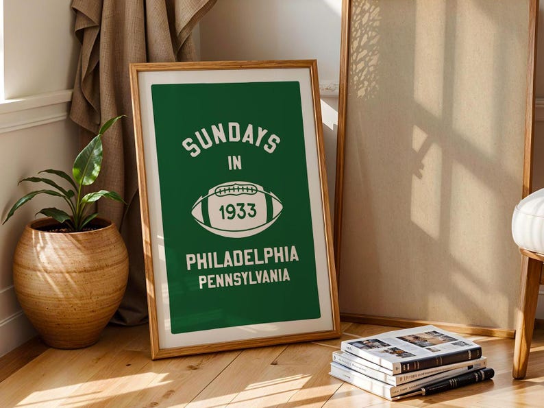K&ouml;nnte beinhalten: Ein gerahmtes gr&uuml;nes Poster mit wei&szlig;em Text, der "Sundays in 1933 Philadelphia Pennsylvania" lautet, und einer wei&szlig;en Fu&szlig;ballgrafik.