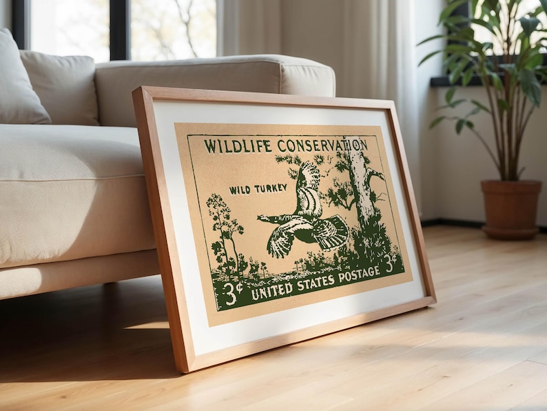 May include: Framed vintage print with a green illustration of a wild turkey in flight on a tan background. Text reads "Wildlife Conservation" and "United States Postage 3&cent;". The print is in a light wood frame.