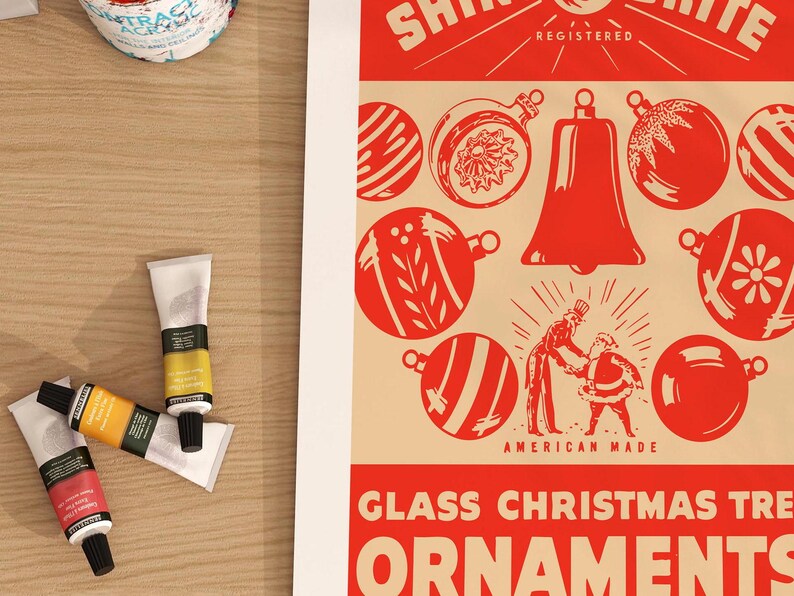 Op de afbeelding: Vintage advertentie voor Shinybrite glazen kerstboomversieringen. De advertentie toont een rode bel en verschillende rode en witte kerstballen met een feestelijk ontwerp. De tekst luidt "Shinybrite Registered American Made Glass Christmas Tree Ornaments".