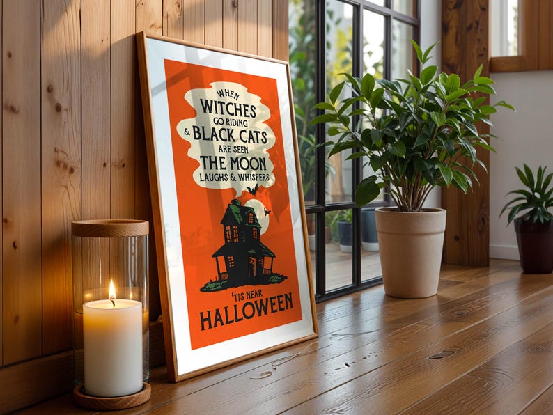 May include: A framed Halloween poster with an orange background and the text "When witches go riding & black cats are seen the moon laughs & whispers 'tis near Halloween." A lit candle sits nearby.