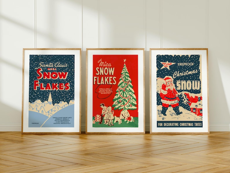 May include: Three vintage Christmas snow flake decorations in framed posters. The left poster is blue with white snowflakes and the text "Santa Claus with Snow Flakes". The middle poster is red with a green Christmas tree and the text "Mica Snow Flakes". The right poster is blue with a white Santa Claus and the text "Fireproof Christmas Snow".