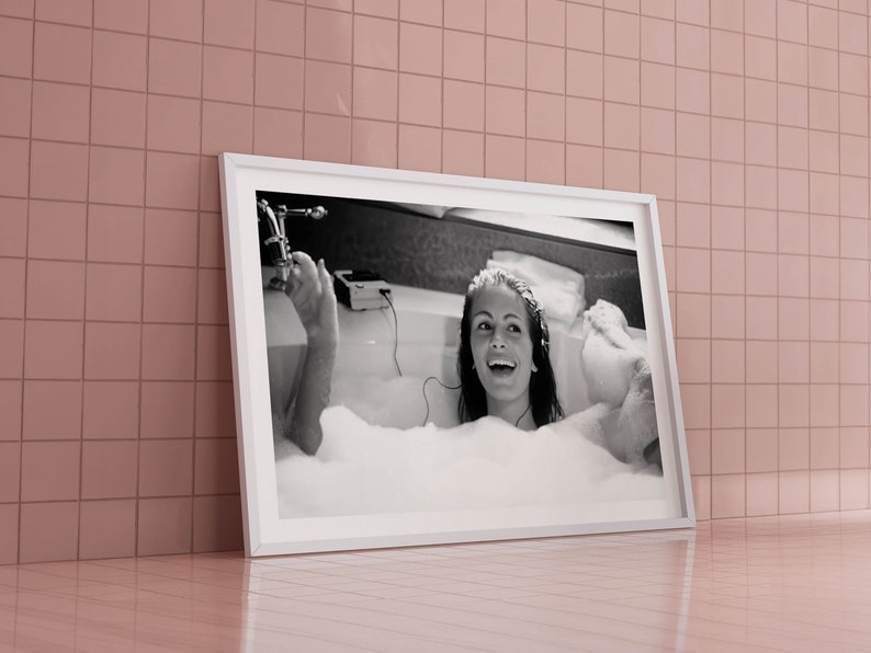 Peut inclure: Photographie en noir et blanc d'une femme dans une baignoire avec des bulles. Elle sourit et a les cheveux relev&eacute;s. La photo est encadr&eacute;e dans un cadre blanc.