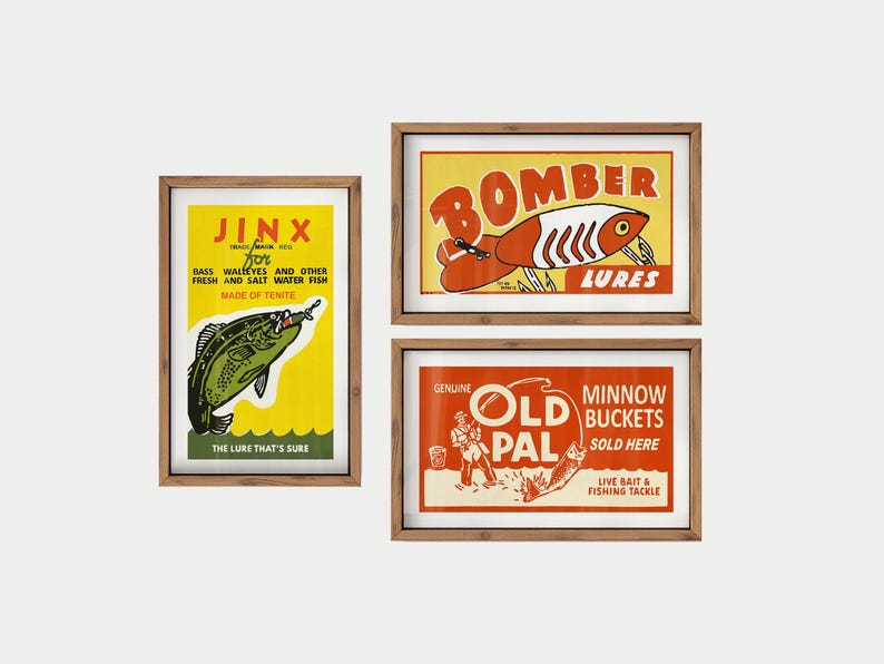 May include: Three framed vintage fishing lure advertisements. The top right poster reads "Bomber Lures" with a red and white lure illustration. The bottom right poster says "Old Pal Minnow Buckets". The left poster says "Jinx for Bass, Walleyes and other fresh and salt water fish".