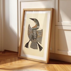 May include: A framed art print featuring a stylized illustration of a bird with outstretched wings. The bird has a long neck and beak, with detailed feather patterns in shades of gray, brown, and teal. The artwork is set against a cream-colored background.