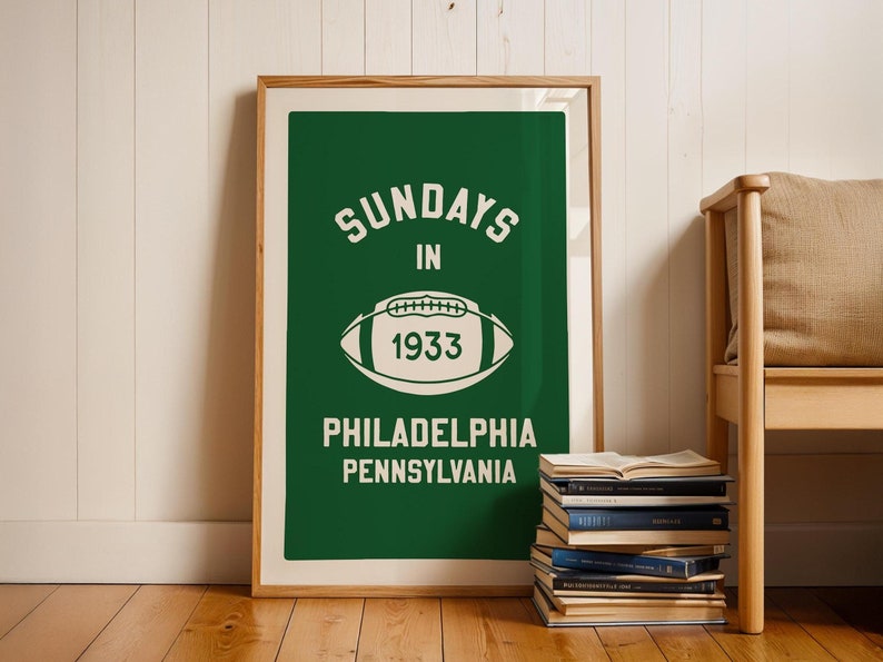 K&ouml;nnte beinhalten: Ein gerahmtes gr&uuml;nes Poster mit wei&szlig;em Text, der "Sundays in 1933 Philadelphia Pennsylvania" lautet, und einer wei&szlig;en Illustration eines Fu&szlig;balls.
