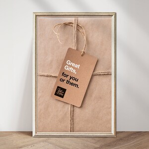 Puede incluir: Una bolsa de regalo de papel marr&oacute;n con una cuerda marr&oacute;n atada alrededor. Una etiqueta de regalo marr&oacute;n con texto blanco dice "Great Gifts, for you or them." La etiqueta est&aacute; atada a la cuerda con un peque&ntilde;o logotipo negro que dice "Just Add Love".