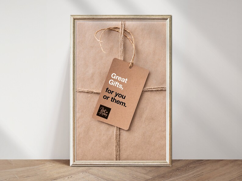 Puede incluir: Una bolsa de regalo de papel marr&oacute;n con una cuerda marr&oacute;n atada alrededor. Una etiqueta de regalo marr&oacute;n con texto blanco dice "Great Gifts, for you or them." La etiqueta est&aacute; atada a la cuerda con un peque&ntilde;o logotipo negro que dice "Just Add Love".