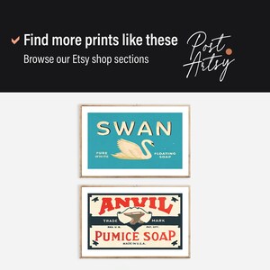May include: Two framed vintage prints. The top print displays "SWAN" above a swan illustration on a teal background. The bottom print reads "ANVIL PUMICE SOAP" with a hammer and anvil graphic. Both are in wooden frames.