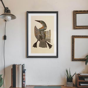 May include: A framed print of a bird with outstretched wings, featuring shades of brown, gray, and beige. The artwork is displayed on a cream-colored wall, alongside two smaller framed mirrors and a wooden shelf with plants and books.