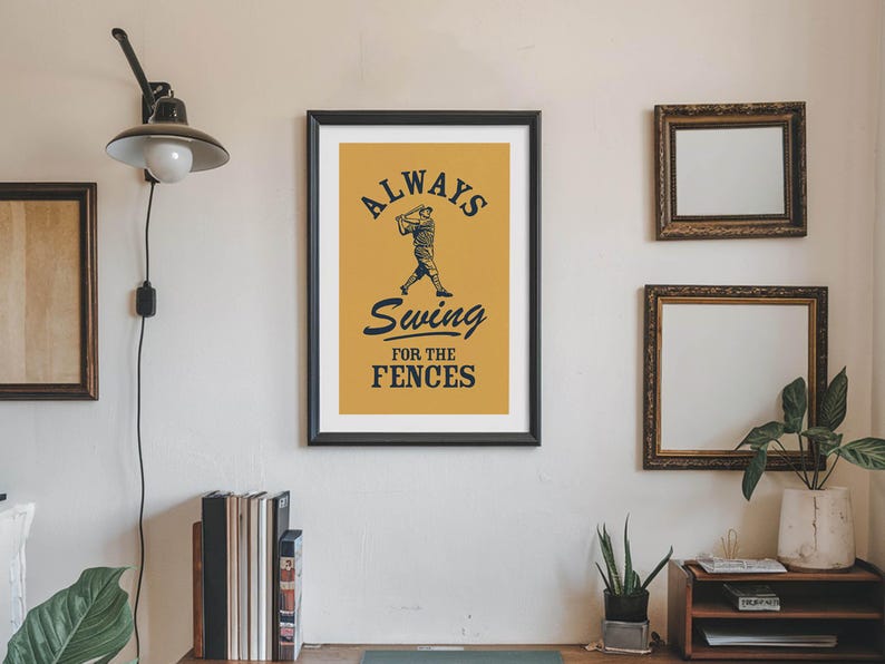 May include: Framed baseball-themed art print with a mustard-yellow background and black text that reads "Always Swing for the Fences." The artwork features a baseball player in silhouette.