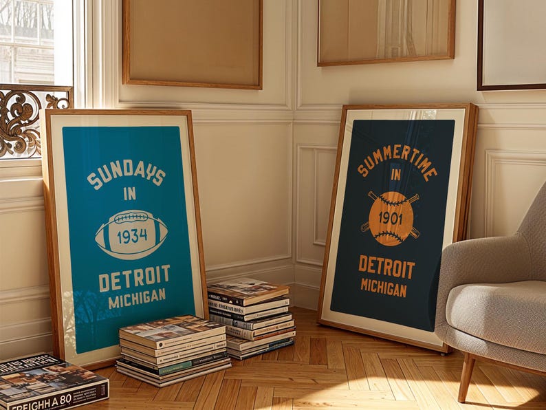 Peut inclure: Deux affiches encadr&eacute;es dans un sch&eacute;ma de couleurs bleu et blanc. L'affiche de gauche dit "Sundays in Detroit Michigan 1934" avec un graphique de football. L'affiche de droite dit "Summertime in Detroit Michigan 1901" avec un graphique de baseball.