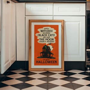 May include: A framed Halloween-themed poster with an orange background and a vintage design. The poster features a haunted house, bats, and the text "WHEN WITCHES GO RIDING & BLACK CATS ARE SEEN THE MOON LAUGHS & WHISPERS 'TIS NEAR HALLOWEEN".