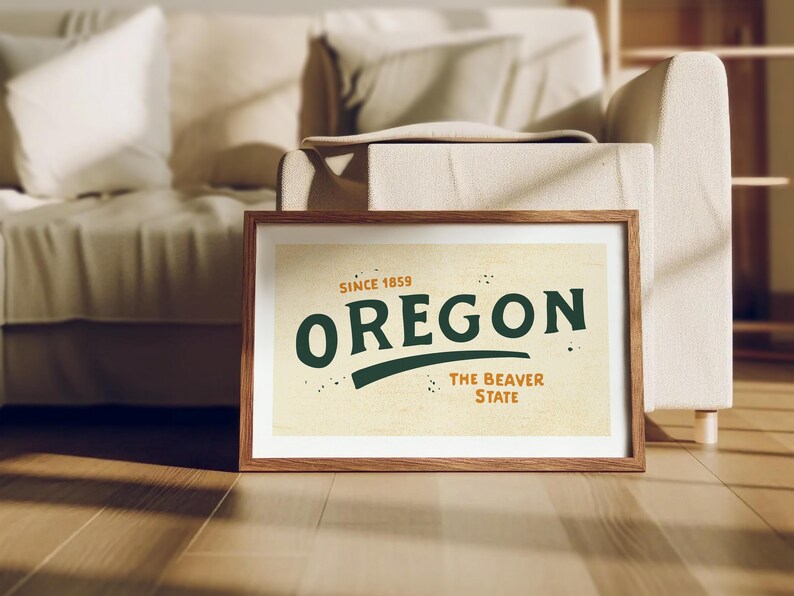 May include: A framed print with a vintage design featuring the text "Oregon, Since 1859, The Beaver State" in green and orange lettering on a beige background.