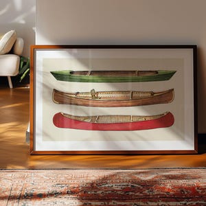 May include: Framed art print featuring three canoes in green, brown, and red. The boats are depicted in a detailed, illustrative style, showcasing their shape and design. The artwork is displayed on a wooden floor.