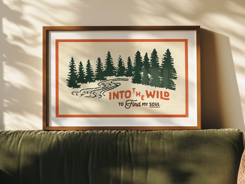 Puede incluir: Una impresi&oacute;n enmarcada con una est&eacute;tica vintage que presenta una escena de bosque con un r&iacute;o sinuoso y el texto "INTO THE WILD TO FIND MY SOUL."