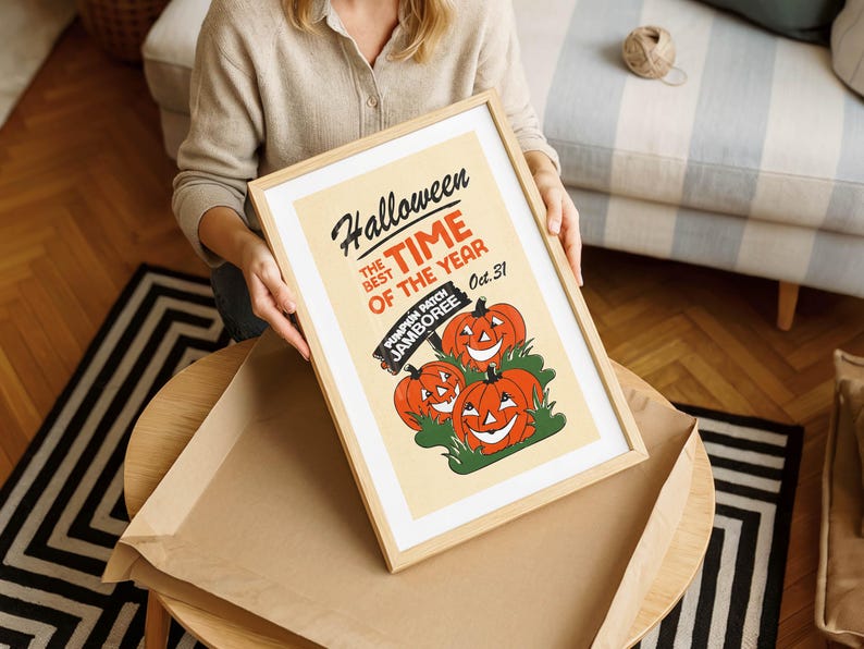 May include: A framed Halloween poster with a light wood frame. The poster features three smiling orange pumpkins and the text "Halloween, the best time of the year, Oct. 31". The words "Pumpkin Patch Jamboree" are also included.