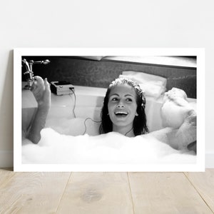 Peut inclure: Une photographie en noir et blanc d'une femme dans un bain, souriante et &eacute;coutant de la musique. Elle est entour&eacute;e de bulles et a un lecteur de cassette au bord de la baignoire.
