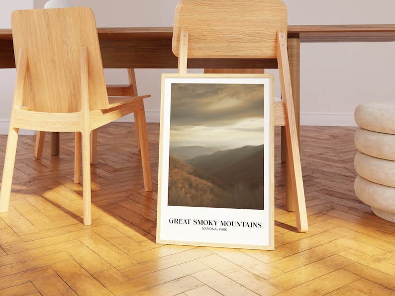 Op de afbeelding: Een ingelijste print van een schilderachtig uitzicht op het Great Smoky Mountains National Park. De afbeelding toont een bergketen met een bewolkte lucht op de achtergrond. De tekst "Great Smoky Mountains National Park" is onder de afbeelding gedrukt.