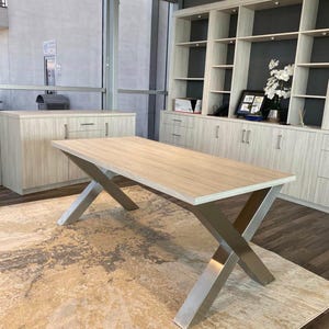 Axis Brushed Stainless Steel X-Frame Table Legs under a light wood top