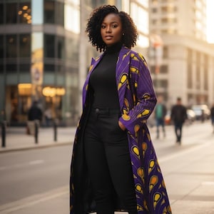 Op de afbeelding: Een vrouw draagt een lange paarse jas met een geel druppelpatroon, een zwarte coltrui en een zwarte broek. De jas is open en onthult de outfit eronder. De achtergrond toont een stadsstraat met gebouwen en voetgangers.