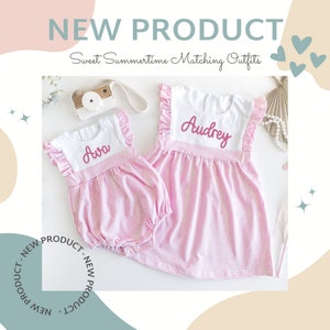 May include: A matching set consisting of a pink and white striped bubble romper with the name Ava embroidered in pink and a pink and white striped dress with the name Audrey embroidered in pink. Both garments feature white bodices and ruffled sleeves.