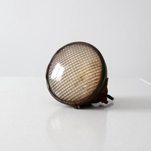 May include: A vintage, rusty, green and brown metal spotlight with a clear, ridged glass lens.
