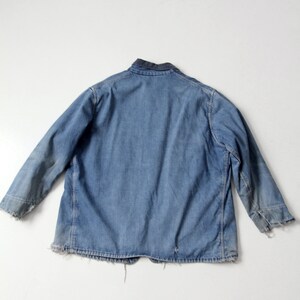 K&ouml;nnte beinhalten: Eine blaue Jeansjacke mit dunkelblauem Kragen. Die Jacke hat einen ausgefransten Saum und &Auml;rmelb&uuml;ndchen.