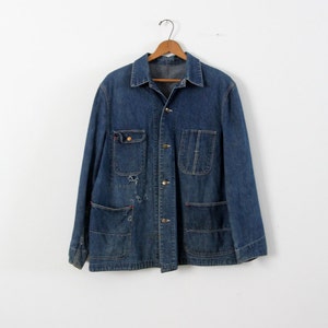 K&ouml;nnte beinhalten: Eine vintage blaue Jeans-Arbeitsjacke mit mehreren Taschen und Knopfverschl&uuml;ssen.