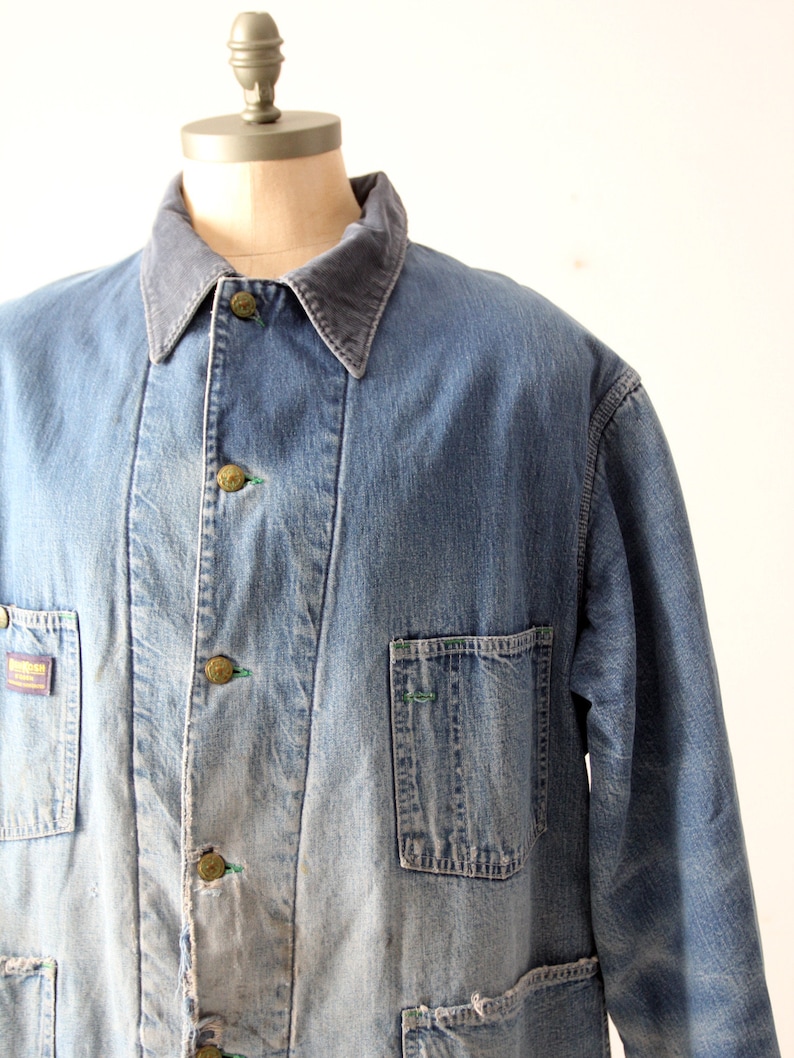 K&ouml;nnte beinhalten: Eine blaue Jeans-Arbeitsjacke mit einem Cordkragen. Die Jacke hat mehrere Taschen und einen ausgewaschenen Look.