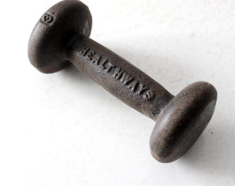 May include: A vintage cast iron dumbbell with the word "HEALTHWAYS" embossed on the handle. The dumbbell is marked with the number "9" on one end.