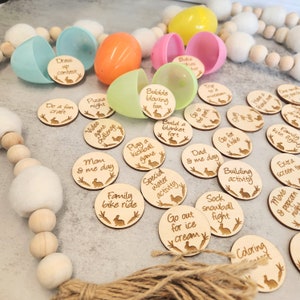 May include: Wooden Easter egg hunt activity with 20 different activities written on each round wooden token. The activities include family bike ride, go out for ice cream, play a kickball game, build a blanket fort, and more. The tokens are surrounded by plastic Easter eggs and a garland of wooden beads.