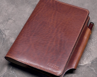 May include: A brown leather notebook cover with a pen holder and the word "Betzel" embossed on the front.
