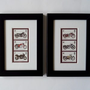 May include: Two black framed prints of vintage motorcycle stamps. The stamps feature images of motorcycles from different eras, with the year and model of each motorcycle listed on the stamp. The stamps are arranged in a vertical column, with the oldest motorcycle at the top and the newest motorcycle at the bottom.
